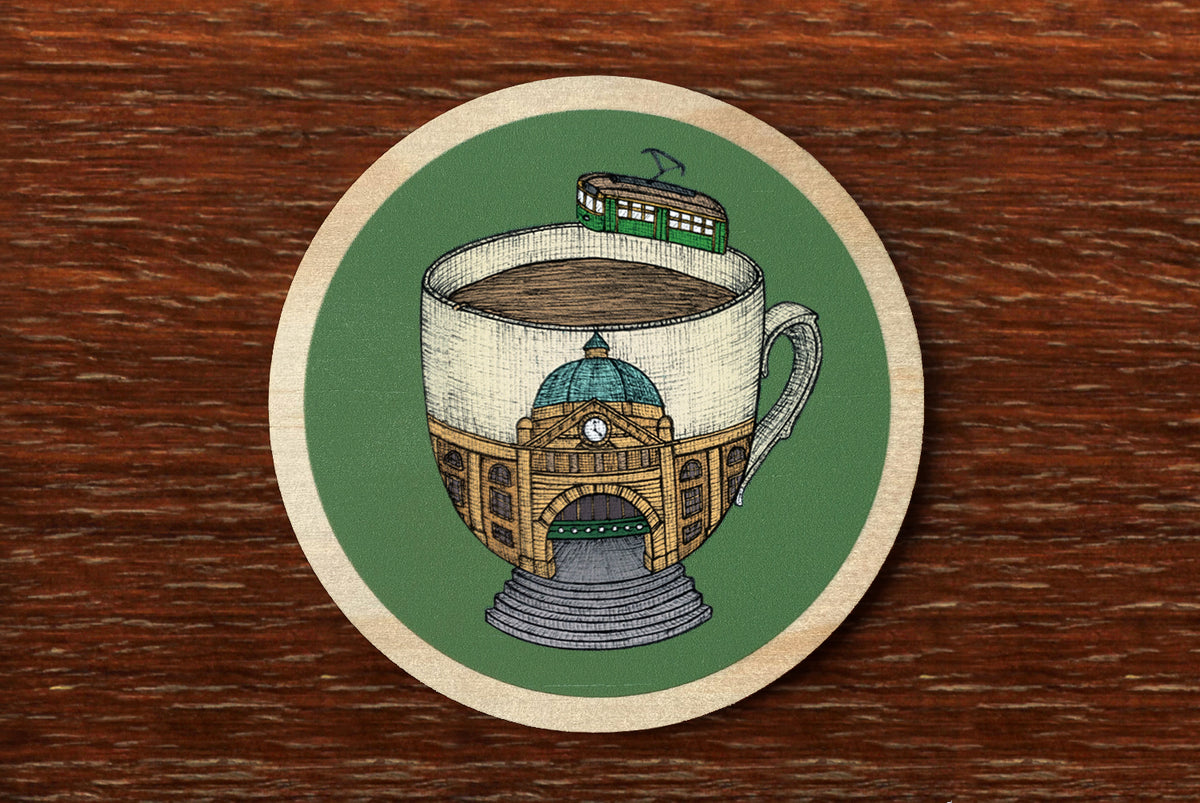 Melbourne Coaster with a design of a teacup featuring Flinders Street Station, on a wooden surface