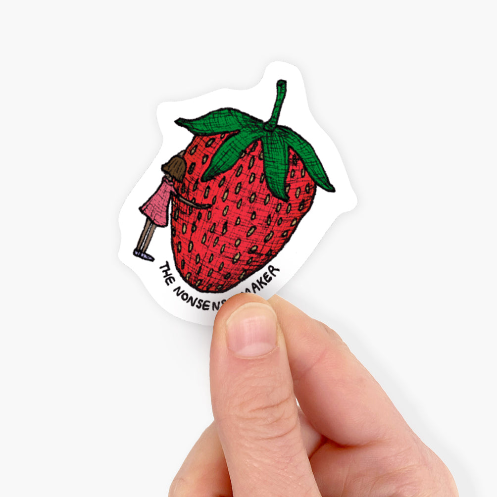 Sticker of a strawberry with a character holding a megaphone, held by a hand on a white background.