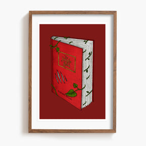Framed artwork of a red The Jungle Book with green leaves on a white background.