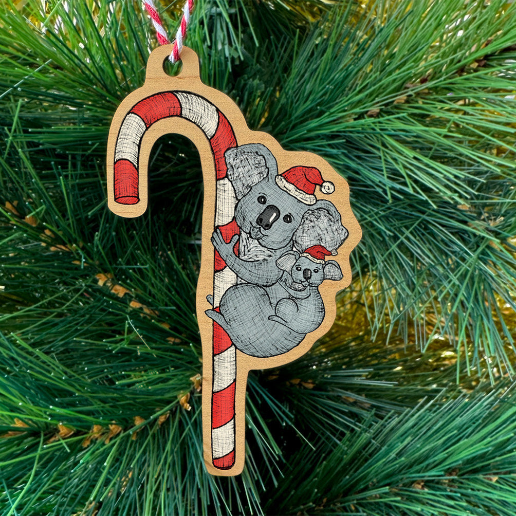 Decorative Christmas ornament shaped like a candy cane with two koalas on a green Christmas tree.