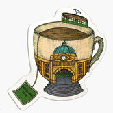 Magnet with an illustration of a Flinders street station inside a large tea cup with a tea bag labelled Melbourne love.