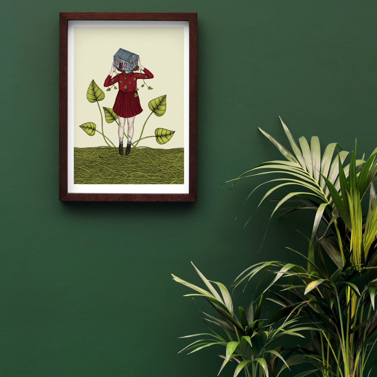 art print of a girl holding a house in a frame on a green wall